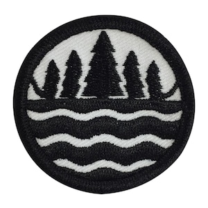 May include: Black and white embroidered patch with a circle design. The center of the circle features a row of five pine trees in front of a wavy line representing water.