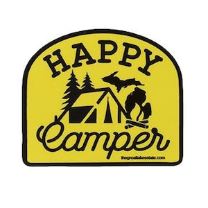 May include: Yellow arched sticker with black text that reads "Happy Camper" with a silhouette of a tent, trees, a campfire, and the state of Michigan. The text "thegreatlakesstate.com" is at the bottom.