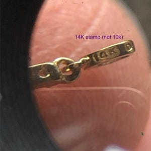 May include: Close-up of a gold chain with a 14K stamp. The stamp is clear and easy to read.