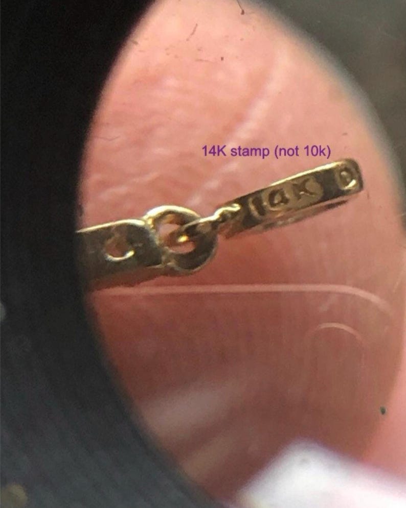 May include: Close-up of a gold chain with a 14K stamp. The stamp is clear and easy to read.