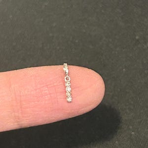 May include: A delicate silver chain with a row of small, clear gemstones hanging from it.