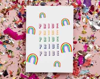 May include: A white card with the word "PRIDE" repeated four times in rainbow colors. The card is surrounded by colorful confetti on a pink background.