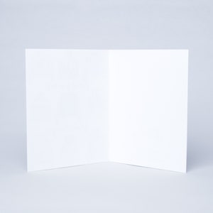 May include: A blank white card folded in half, ready for writing or drawing.