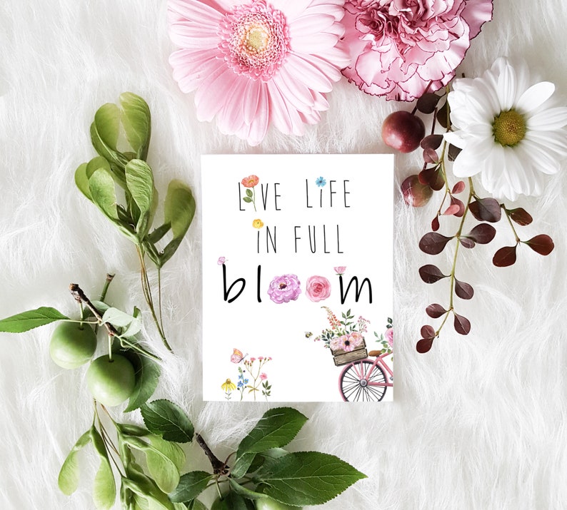 May include: A white card with the text "Live Life in Full Bloom" and a watercolor illustration of a bicycle with a basket full of flowers.