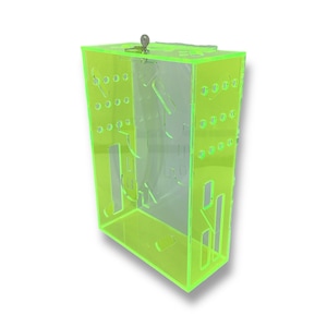 May include: A bright green acrylic box with a hinged lid and a small metal latch. The box has a series of small holes on the sides and a clear plastic interior.