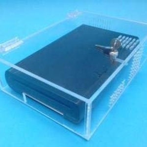 May include: A clear acrylic box with a lock and key, containing a black leather-bound journal.