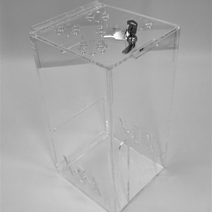 May include: A clear acrylic box with a lock and key. The box has a slot on the top for inserting items. The box is labeled "X-RAY" on the side.
