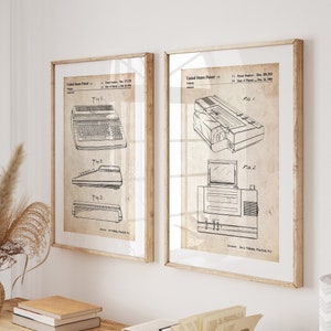 Op de afbeelding: Twee vintage-stijl prints van computerpatentetekeningen. De prints zijn ingelijst in natuurlijke houten frames en hangen aan een witte muur. De prints hangen boven een houten tafel met een boek en een vaas met gedroogde bloemen.