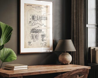 Puede incluir: Impresión enmarcada de patente de guitarra vintage. La impresión presenta un dibujo técnico detallado de una guitarra, con texto que incluye la fecha 10 de abril de 1956. El marco es marrón y la impresión tiene un tono sepia.