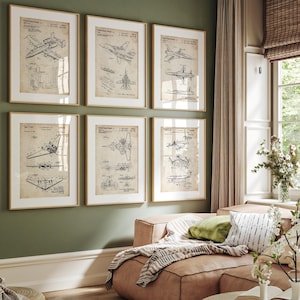 May include: Six framed vintage-style aviation patent prints. Each print features detailed black and white diagrams of different aircraft designs. The prints are displayed on a green wall above a pink sofa, creating a decorative and thematic display.