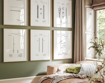 Puede incluir: Seis impresiones enmarcadas de patentes de bolígrafos en marcos dorados cuelgan de una pared verde. Las impresiones en blanco y negro muestran diagramas detallados y dibujos técnicos de bolígrafos. La habitación tiene un sofá con cojines y una ventana.