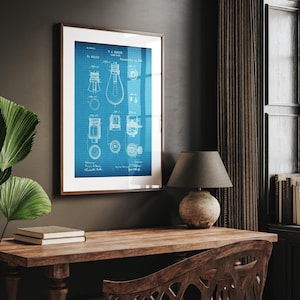 Op de afbeelding: Ingelijste blauwdruk van een gloeilamp patent, met witte technische tekeningen op een blauw raster. De print zit in een bruine houten lijst, ideaal voor huis- of kantoordecoratie. Patent gedateerd 24 oktober 1899.
