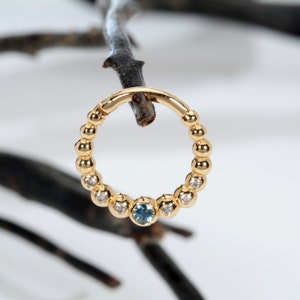 Perforación de oreja con bolas en oro de 14 k y diamantes blancos y topacio azul Daith Jewelty