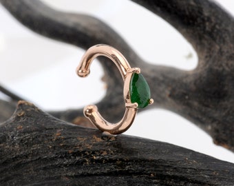 May include: A rose gold ear cuff with a teardrop-shaped green gemstone.