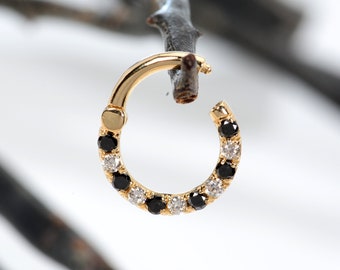 May include: A gold hoop earring with a row of black and white diamonds.