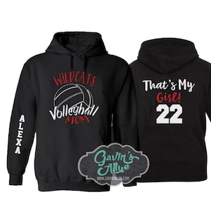 May include: Two black hooded sweatshirts. One sweatshirt has the text "Wildcats Volleyball Mom" with a volleyball graphic. The other sweatshirt has the text "That's My Girl! 22".