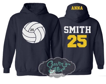 May include: Two navy blue hoodies with white volleyball graphic and text. One hoodie has a white volleyball with the number 25 on it. The other hoodie has the text "ANNA SMITH 25" in white and yellow.