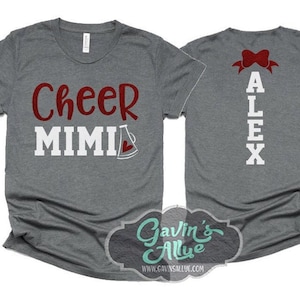 May include: Two grey t-shirts with red and white text. The front shirt says "Cheer Mimi" with a red megaphone. The back shirt says "Alex" with a red bow.