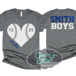 May include: Two gray t-shirts with a baseball theme. One shirt has a white heart-shaped baseball with the numbers 12 and 25 and the word "Pirates" underneath. The other shirt has the text "SMITH BOYS" in blue glitter letters.