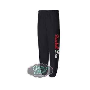Op de afbeelding: Zwarte sweatpants met de tekst "Baseball Mom" in rood en wit op het rechterbeen.