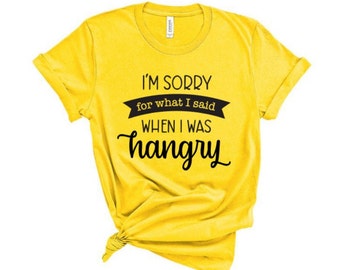 May include: Yellow t-shirt with black text that reads "I'm sorry for what I said when I was hangry".