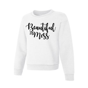 May include: White crew neck sweatshirt with long sleeves. The words "Beautiful Mess" are printed in black cursive script across the front. The sweatshirt has a classic, casual style.