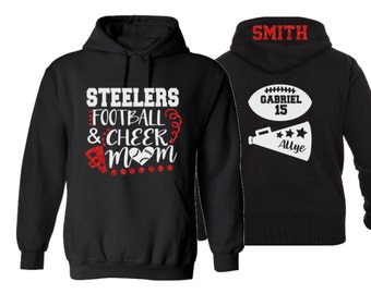 May include: Black hooded sweatshirt with the text "Steelers Football & Cheer Mom" in white with red glitter accents. The back of the sweatshirt has the text "Smith" in white glitter and a white football with the text "Gabriel 15" and a white megaphone with the text "Allye" in white glitter.