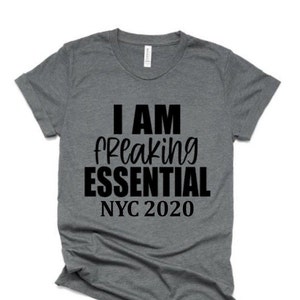 May include: A heather grey t-shirt with black text that reads "I AM freaking ESSENTIAL NYC 2020".