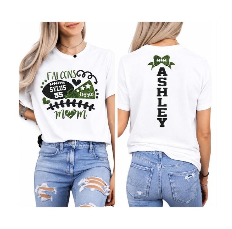 Op de afbeelding: Een wit t-shirt met korte mouwen en een groen-zwarte afbeelding op de voorkant met een football, megafoon en de tekst "FALCONS SYLUS 55 lizzie mom". De achterkant toont de naam "ASHLEY" verticaal met een afbeelding van een groene strik.