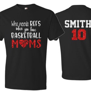 May include: Two black t-shirts. One shirt says "Who needs refs when you have basketball moms" with a red basketball and heart. The other shirt has "Smith 10" in red glitter.
