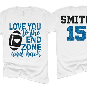 May include: Two white t-shirts, one with the text "LOVE YOU TO THE END ZONE and back" and a football graphic, and the other with the text "SMITH 15" in blue glitter.