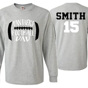 Op de afbeelding: Grijs longsleeve t-shirt met een zwart-witte voetbalafbeelding met de tekst "Panthers Football Dad". De linkermouw heeft de naam "Jacob" verticaal gedrukt. De achterkant van het shirt heeft de naam "Smith" en het nummer "15" in wit gedrukt.