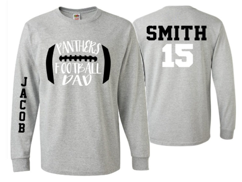 Op de afbeelding: Grijs longsleeve t-shirt met een zwart-witte voetbalafbeelding met de tekst "Panthers Football Dad". De linkermouw heeft de naam "Jacob" verticaal gedrukt. De achterkant van het shirt heeft de naam "Smith" en het nummer "15" in wit gedrukt.