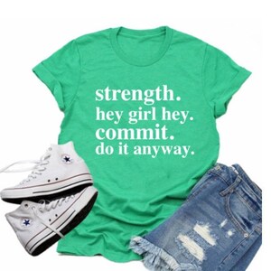 May include: A green t-shirt with the text "strength. hey girl hey. commit. do it anyway."