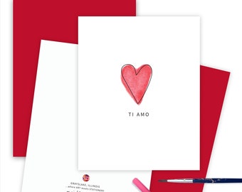 May include: A white card with a red heart and the words "TI AMO" in black text. The card is surrounded by a red envelope and a red background.