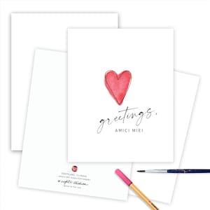 May include: A greeting card with a red watercolor heart and the text "greetings, amici miei".