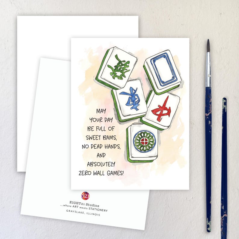Peut inclure: Carte de v&oelig;ux avec une illustration &agrave; l'aquarelle de tuiles de Mahjong vertes, bleues et rouges. Le texte dit : "Que votre journ&eacute;e soit pleine de doux bams, pas de mains mortes et absolument z&eacute;ro jeu de mur !" Deux pinceaux sont &agrave; droite.