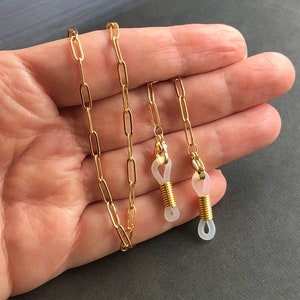 May include: Gold chain with clear silicone ends for glasses.
