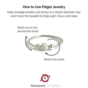 May include: Silver fidget ring with three beads. The center bead is larger and has a textured surface. The beads can be moved around the ring to help manage anxiety and stress.