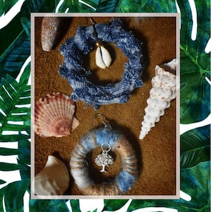 Peut inclure: Deux paires de boucles d'oreilles sur un fond brun avec des coquillages. Une paire est en tissu denim et l'autre est en laine avec un petit charme d'arbre.