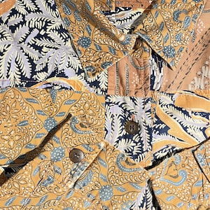 Peut inclure: Gros plan sur une chemise à motifs marrons, bleus et blancs avec une étiquette indiquant "RUF HEWN".