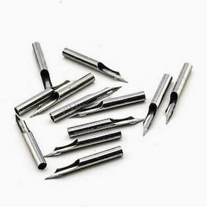 Puede incluir: Una colecci&oacute;n de plumillas de caligraf&iacute;a plateadas. Cada plumilla tiene una punta afilada y una ranura central. Las plumillas son cil&iacute;ndricas con un agujero para la tinta.