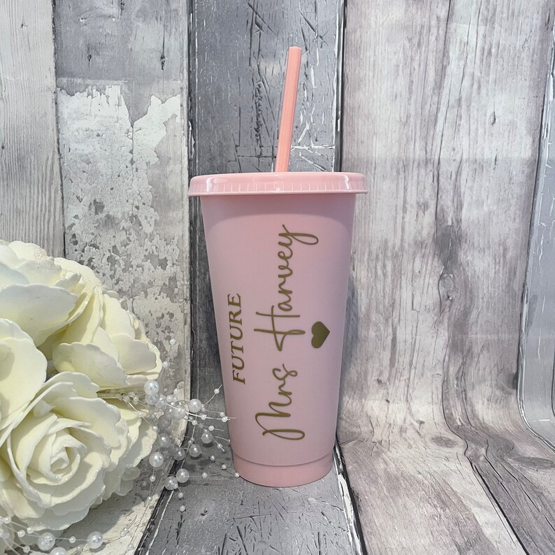 Puede incluir: Vaso reutilizable rosa con una pajita dorada y el texto "Future Mrs Harvey" con un peque&ntilde;o coraz&oacute;n.