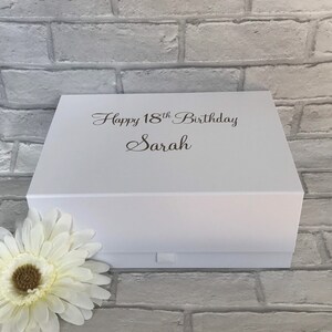 May include: White gift box with a white ribbon and the text "Happy 18th Birthday Sarah" printed on the top.