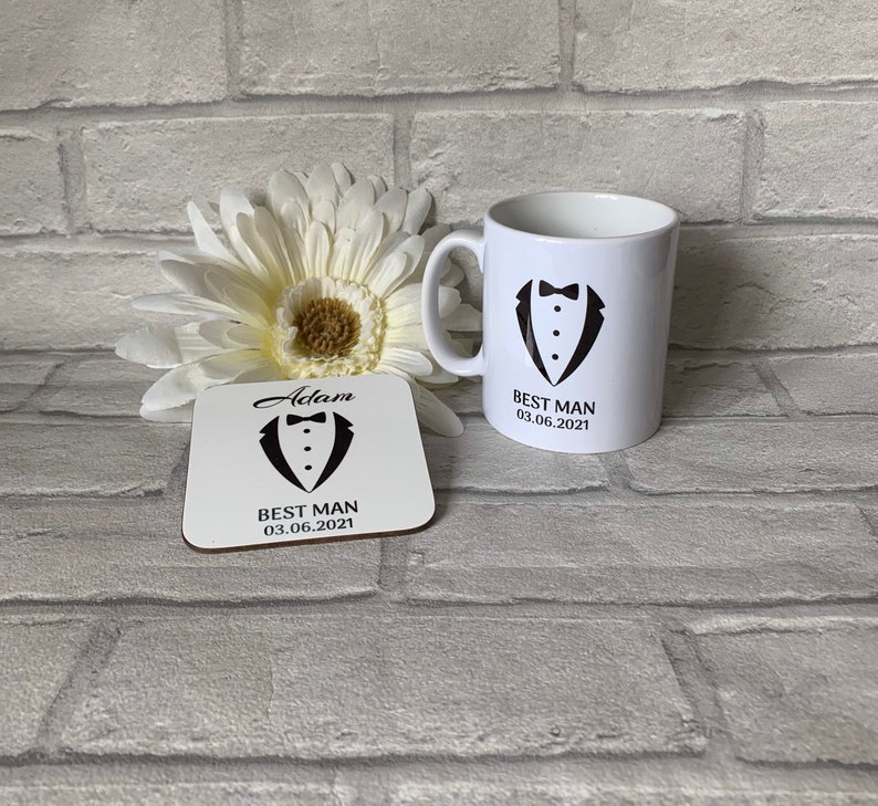May include: White ceramic mug with a black tuxedo graphic and the text "Best Man 03.06.2021". A matching white coaster with the text "Adam Best Man 03.06.2021" and a tuxedo graphic.