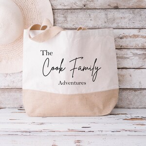 May include: A white canvas tote bag with brown handles. The bag has the text "The Cook Family Adventures" printed on it.