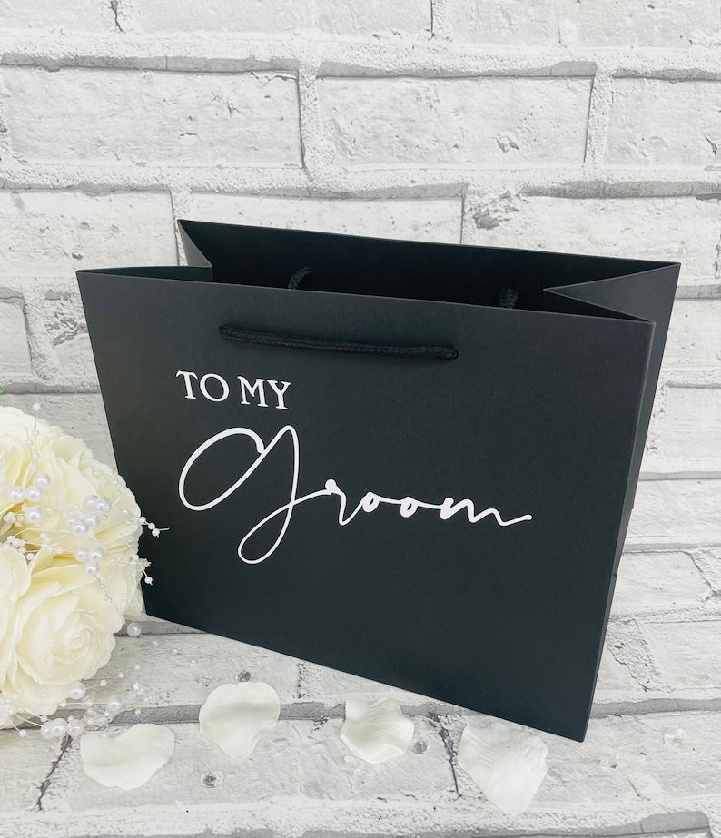 May include: Black gift bag with white text that says "To My Groom".