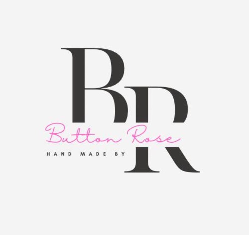 May include: Logo for Button Rose, featuring the letters "BR" in a bold, black serif font. The words "Button Rose" are in a cursive, pink font, with "HAND MADE BY" in a smaller, black font below.