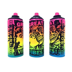 Puede incluir: Tres botes de pintura en aerosol con diseños coloridos. Los botes son de color rosa, amarillo, naranja, verde y azul. El texto en los botes dice "Great Vibes", "Heart Vibes" y "Death Throbs".