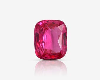 May include: A vibrant pink gemstone with a cushion cut. The gemstone is faceted and has a high polish.